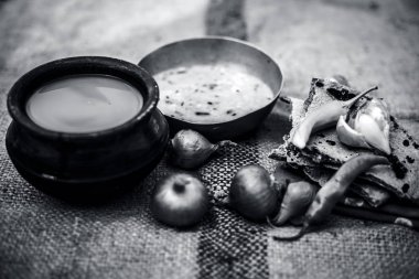 Beyaz mercimek, inci darı roti veya chapati ve ayran veya yeşil biber ve bazı soğan ile şabaile gunny çanta arka plan üzerinde yoksul adamın tam süt kapatın. siyah beyaz