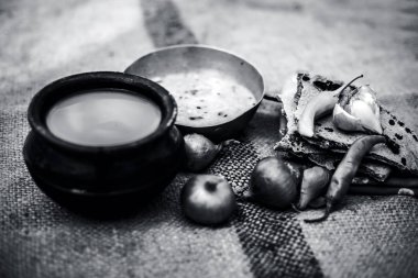 Beyaz mercimek, inci darı roti veya chapati ve ayran veya yeşil biber ve bazı soğan ile şabaile gunny çanta arka plan üzerinde yoksul adamın tam süt kapatın. siyah beyaz