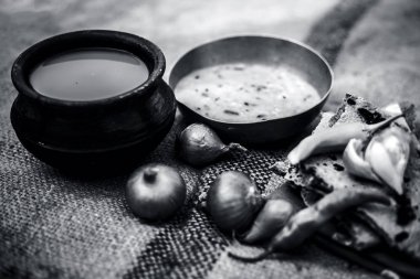 Beyaz mercimek, inci darı roti veya chapati ve ayran veya yeşil biber ve bazı soğan ile şabaile gunny çanta arka plan üzerinde yoksul adamın tam süt kapatın. siyah beyaz