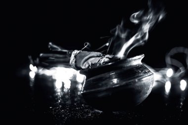 Popüler ve ünlü antik yöntem sivrisinek veya sivrisinek kovucu öldürmek için. yani bir tencerede bazı ağaçların bazı çubukları yakma. Işıkların bulanık arka planıyla çekimi kapatma.