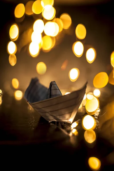 Uzavření Papírového Člunu Dřevěném Povrchu Rozmyšlením Světel Vánočních Dekorací Dekorativních — Stock fotografie
