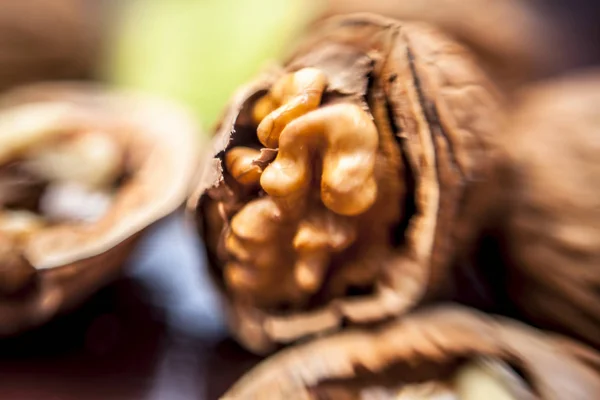 Macro shot of raw organic walnuts in sell on wooden surface.