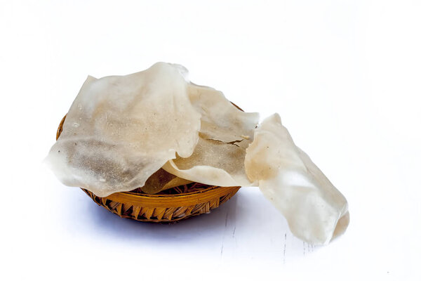 Popular Indian and Asian crispy snack dish i.e. Raw uncooked Papad or rice flour papadum in  a hamper isolated on white.