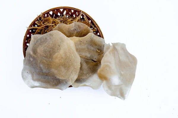 Popular Indian and Asian crispy snack dish i.e. Raw uncooked Papad or rice flour papadum in  a hamper isolated on white.