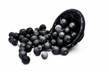Kırmızı renkli popüler Hint ve Asya meyveleri veya bor veya bers beyaz yani Chaniya bor veya chani bor veya hint jujubes bir kil kase üzerinde izole yakın.