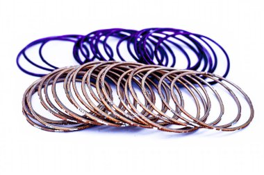 Beyaz üzerine izole edilmiş mor ve turuncu renkli metal bileziklerin yakın çekim.