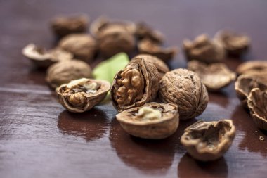 Cevizlerin kabuk olarak kapatılması ve bazılarının kahverengi renkli ahşap yüzeyde kırılması.