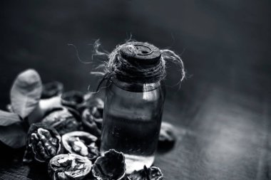 Ahşap yüzeyüzerinde ham duvar fındık ile şeffaf bir cam şişe de bitkisel organik ayıklanmış ceviz yağı yakın.