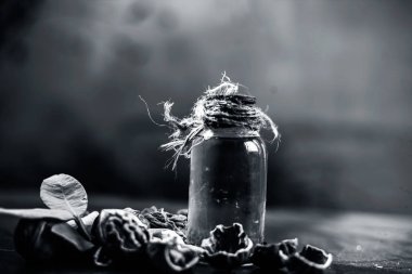 Ahşap yüzeyüzerinde ham duvar fındık ile şeffaf bir cam şişe de bitkisel organik ayıklanmış ceviz yağı yakın.