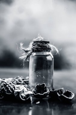 Ahşap yüzeyüzerinde ham duvar fındık ile şeffaf bir cam şişe de bitkisel organik ayıklanmış ceviz yağı yakın.