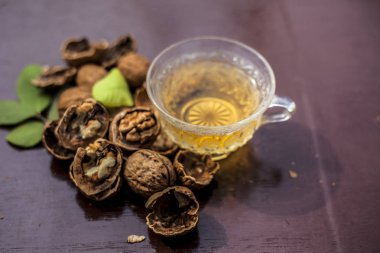 Duvar fıstığı veya ceviz çayı bitkisel organik çay kabuk çiğ duvar somun ile şeffaf bir cam fincan ve kırık da kapatın.