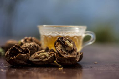 Duvar fıstığı veya ceviz çayı bitkisel organik çay kabuk çiğ duvar somun ile şeffaf bir cam fincan ve kırık da kapatın.