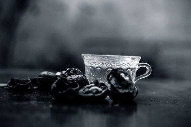 Duvar fıstığı veya ceviz çayı bitkisel organik çay kabuk çiğ duvar somun ile şeffaf bir cam fincan ve kırık da kapatın.