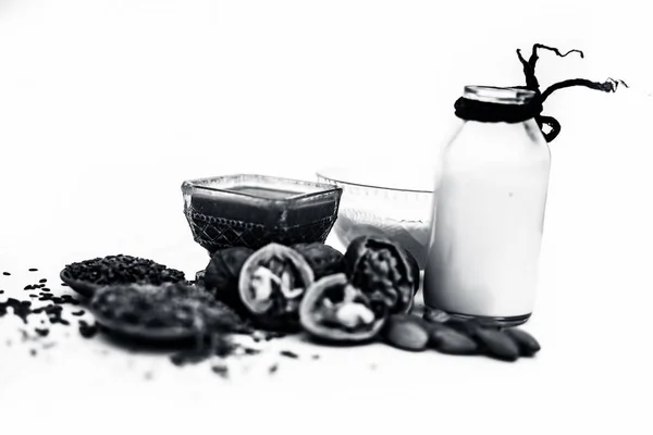 Close up of face mask or face pack of walnut along with flax seed or alsi, almonds,yogurt and milk in a glass bowl   entire raw ingredients isolated on white.