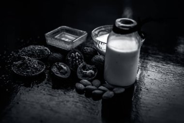 Yüz maskesi veya yüz paketi ceviz keten tohumu veya alsi, badem, yoğurt ve süt ile birlikte bir cam kase ahşap yüzey üzerinde tüm ham maddeler kadar.;