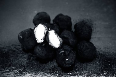 Bunlardan biri kesilmiş siyah renkli ahşap yüzey üzerinde taze organik çiğ su kestane yakın.