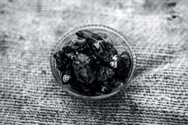 Ham organik hurma veya khajoor veya Phoenix dactylifera bir gunny çanta arka plan üzerinde bir cam kase içinde çekim kapatın.