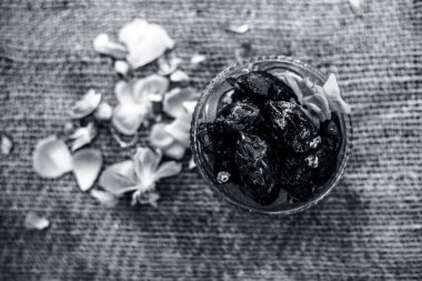 Ham organik hurma veya khajoor veya Phoenix dactylifera bir gunny çanta arka plan üzerinde bir cam kase içinde çekim kapatın.