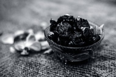 Ham organik hurma veya khajoor veya Phoenix dactylifera bir gunny çanta arka plan üzerinde bir cam kase içinde çekim kapatın.