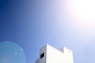 Güneş ve bulutlar ve bir güneş yetenek ile beyaz renkli bina Mimari minimalist çekim.