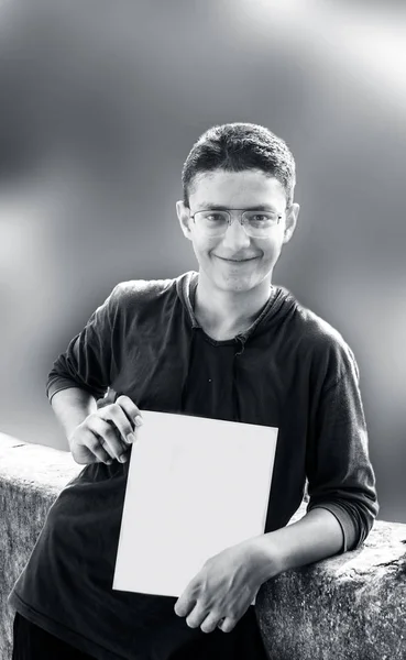 Mladý Muž Brýlích Drží Prázdný List Papíru Usmívá — Stock fotografie