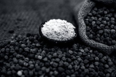 Kahverengi renkli yüzeyüzerinde kil bir kase içinde nohut veya gram dolu bir jut çanta ve zemin veya besan ka atta kapatın.