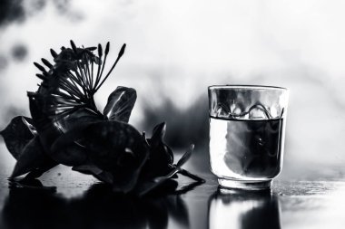 Kırmızı renkli pentas çiçek veya Mısır Star Çiçek veya yasemin şeffaf bir cam kase içinde çıkarılan su ile ahşap yüzeyüzerinde yakın.
