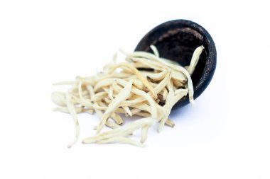 Popüler Hint & Asya ayurveda bitki yakın bir kil kase yani musli veya güvenli musli veya Klorofitum borivilianum erkek gücünü artırmak için ayurvedik tonik olarak kullanılan beyaz izole.