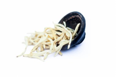 Popüler Hint & Asya ayurveda bitki yakın bir kil kase yani musli veya güvenli musli veya Klorofitum borivilianum erkek gücünü artırmak için ayurvedik tonik olarak kullanılan beyaz izole.