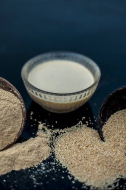 Haşhaş tohumu veya khus veya afyon haşhaş veya ekmek tohumu haşhaş onun çıkarılan bitkisel ve organik artı yararlı hamur veya kalın tentür ile cam bir kase içinde dolu ahşap yüzeyüzerinde Kil kase.