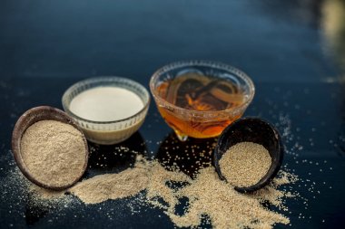 Haşhaş tohumu veya khus veya afyon haşhaş veya ekmek tohumu haşhaş ile çıkarılan bitkisel ve organik artı yararlı hamur veya bal ile cam bir kase kalın tentür dolu ahşap yüzeyüzerinde Kil kase.