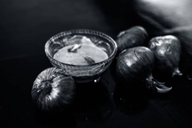 Cam kase içinde ayıklanmış soğan hamuru ve çiğ soğan veya pyaaj veya Allium cepa dolu yakın.