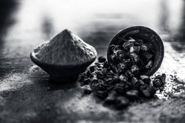 Popüler Hint & Asya ayurveda organik bitki musli veya Chlorophytum borivilianum veya Curculigo orkioidler veya kali moosli ahşap yüzeyüzerinde başka bir kase içinde toz ile bir kil içinde.