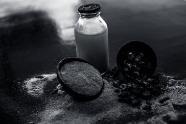 Popüler Hint & Asya ayurveda organik bitki musli veya Chlorophytum borivilianum veya Curculigo orkioidler veya kali moosli süt dolu şeffaf bir cam şişe ile ahşap yüzey üzerinde bir kil.