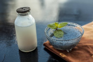 Sabja tohumları veya tatlı fesleğen tohumu veya fesleğen tohumu iyi çiğ süt ile karışık oluşan ahşap yüzeyde asitlik veya kabızlık tedavisi için en iyi ev çare.