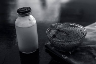 Sabja tohumları veya tatlı fesleğen tohumu veya fesleğen tohumu iyi çiğ süt ile karışık oluşan ahşap yüzeyde asitlik veya kabızlık tedavisi için en iyi ev çare.