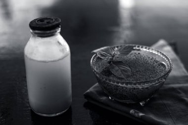 Sabja tohumları veya tatlı fesleğen tohumu veya fesleğen tohumu iyi çiğ süt ile karışık oluşan ahşap yüzeyde asitlik veya kabızlık tedavisi için en iyi ev çare.