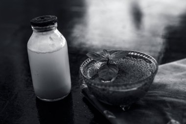 Sabja tohumları veya tatlı fesleğen tohumu veya fesleğen tohumu iyi çiğ süt ile karışık oluşan ahşap yüzeyde asitlik veya kabızlık tedavisi için en iyi ev çare.