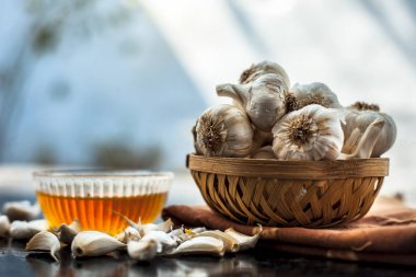 Ham sarımsak ve bal ahşap yüzeyüzerinde ayrı kase ile birlikte düşük yüksek kolesterol ve kan basıncı ve daha birçok tedavisi için kullanılan.