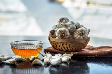 Ham sarımsak ve bal ahşap yüzeyüzerinde ayrı kase ile birlikte düşük yüksek kolesterol ve kan basıncı ve daha birçok tedavisi için kullanılan.