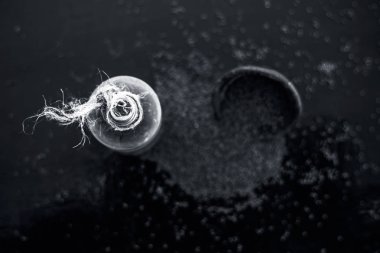 Ham organik bitkisel baharat Hardal tohumu veya sarso veya rai veya Brassica nigra, şeffaf bir cam şişe onun çıkarılan uçucu yağ ile ahşap yüzeyüzerinde bir kil kase içinde.