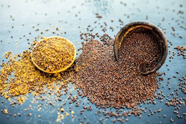 Ham organik bitkisel baharat Hardal tohumu veya sarso veya rai veya Brassica nigra, ahşap yüzeyüzerinde başka bir kase tozu ile birlikte bir kil kase içinde.
