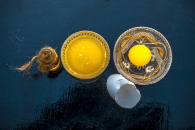 Farklı kaplarda tüm ham maddeler ile bütün yumurta ve hint yağı oluşan bir cam kase ahşap yüzeyinde Saç büyüme çare.