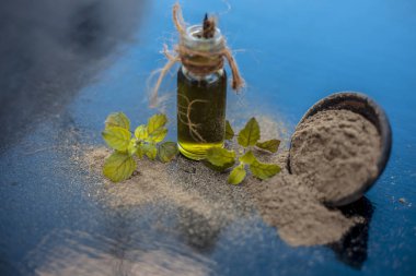 Ayurveda bitki brahmi veya Waterhyssop yağı ahşap yüzeyinde toz ile birlikte küçük bir şeffaf cam şişe.