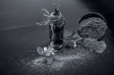 Ayurveda bitki brahmi veya Waterhyssop yağı ahşap yüzeyinde toz ile birlikte küçük bir şeffaf cam şişe.