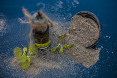 Ayurveda bitki brahmi veya Waterhyssop yağı ahşap yüzeyinde toz ile birlikte küçük bir şeffaf cam şişe.