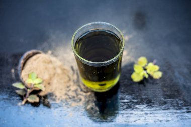 Ayurveda bitki brahmi veya Waterhyssop ahşap yüzeyüzerinde toz ile birlikte şeffaf bir cam onun bitkisel ve yararlı özü ile.