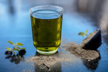 Ayurveda bitki brahmi veya Waterhyssop ahşap yüzeyüzerinde toz ile birlikte şeffaf bir cam onun bitkisel ve yararlı özü ile.