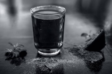 Ayurveda bitki brahmi veya Waterhyssop ahşap yüzeyüzerinde toz ile birlikte şeffaf bir cam onun bitkisel ve yararlı özü ile.