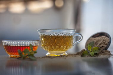 Ayurveda bitki brahmi veya Waterhyssop küçük bir şeffaf cam şişe içinde çay ile birlikte toz ve ahşap yüzeyinde bal bir kase.